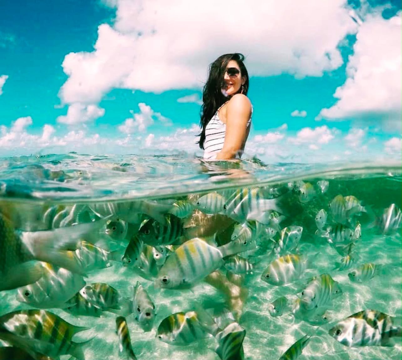 Mulher entre peixinhos nas piscinas naturais